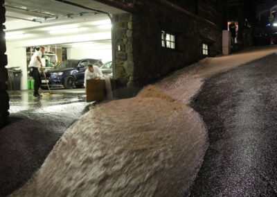 Bach fließt über die Gemeindestraßen